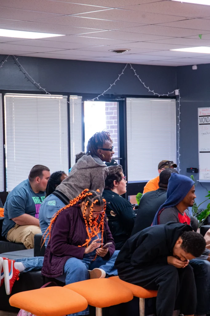 Adults sitting together and listening during a group activity at an adult day support program.