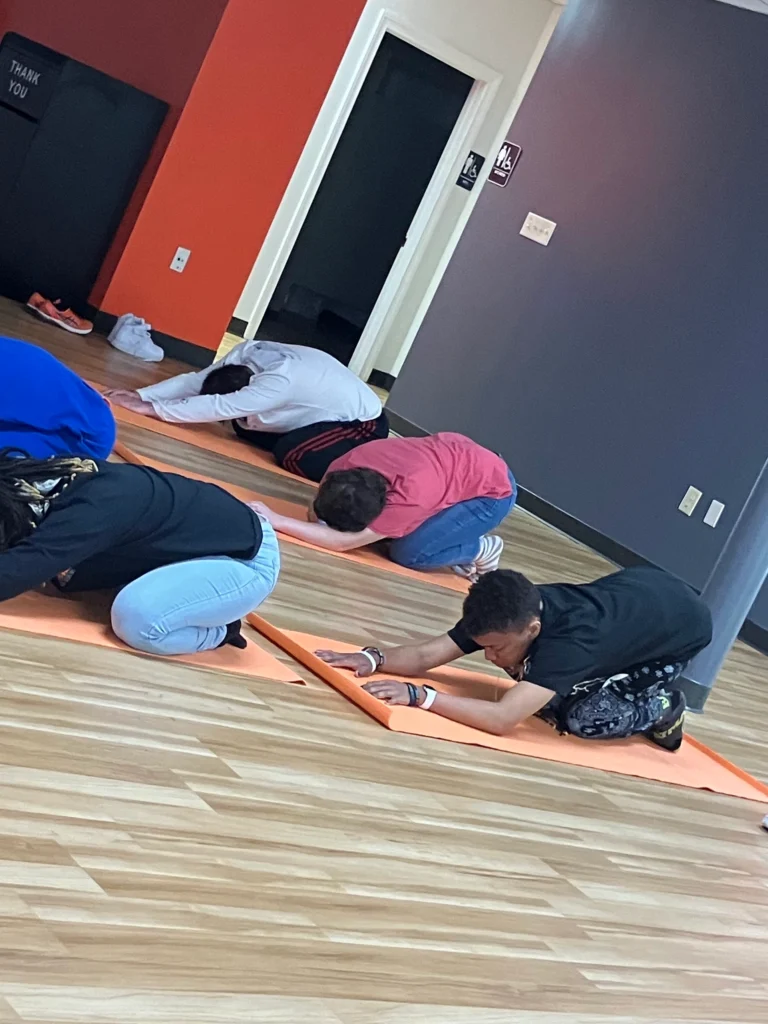 Adults stretching on yoga mats during a wellness activity at an adult day support program.