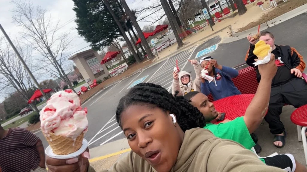 Adults and staff enjoying ice cream together during a community outing with an adult day support program.