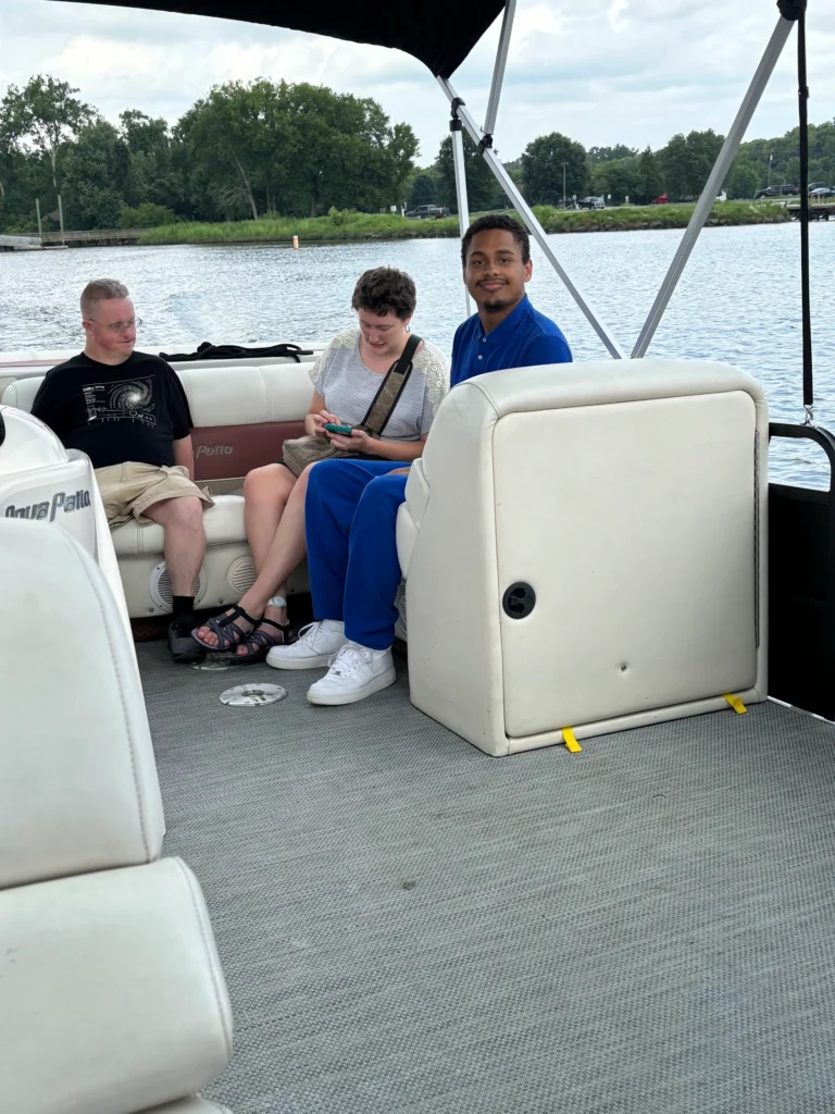 Adults sitting together on a boat during a community outing with an adult day support program.