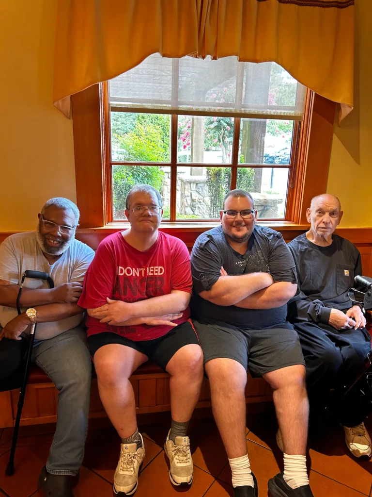 Adults seated together by a window during a community outing with an adult day support program.