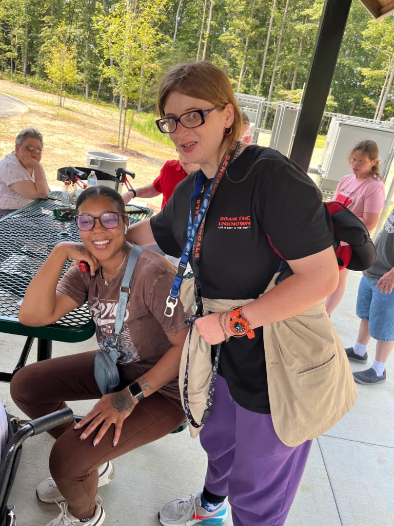 Two adult members smiling together during an outdoor social activity.