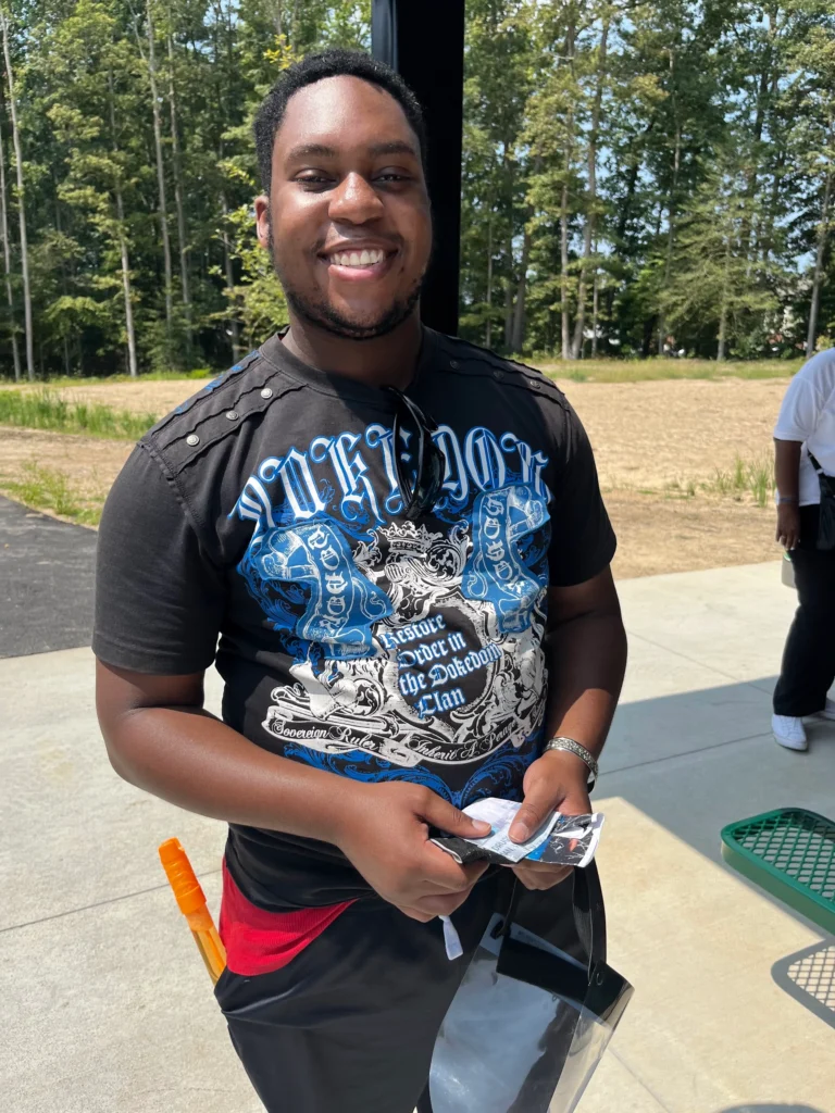 Adult member smiling outdoors during a community activity with an adult day support program.