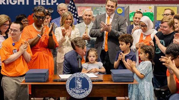 Community members attending an official signing event supporting disability services and inclusion in Virginia.