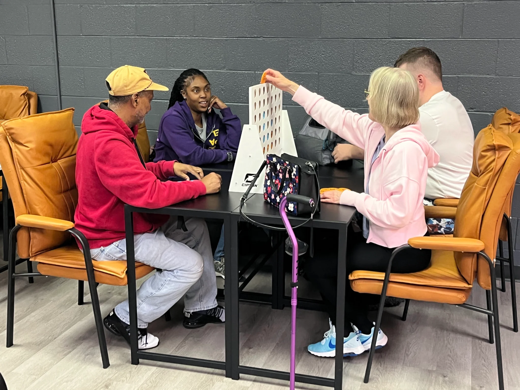 Adults with disabilities and support staff playing a tabletop decision-making game at Smiles Like Yours.