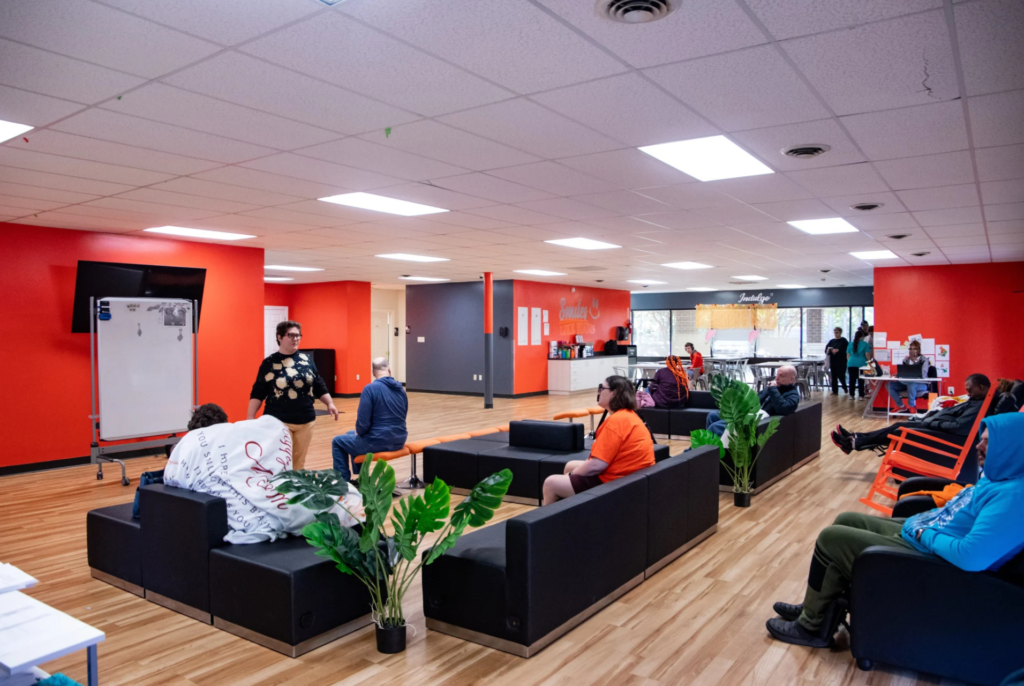 Spacious Smiles Like Yours activity area with adults and staff using shared seating and accessible open spaces.