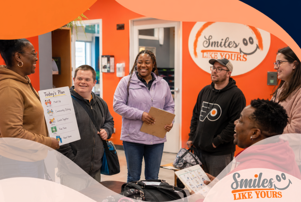 Smiles Like Yours participants and staff planning a community outing in a supportive group setting.