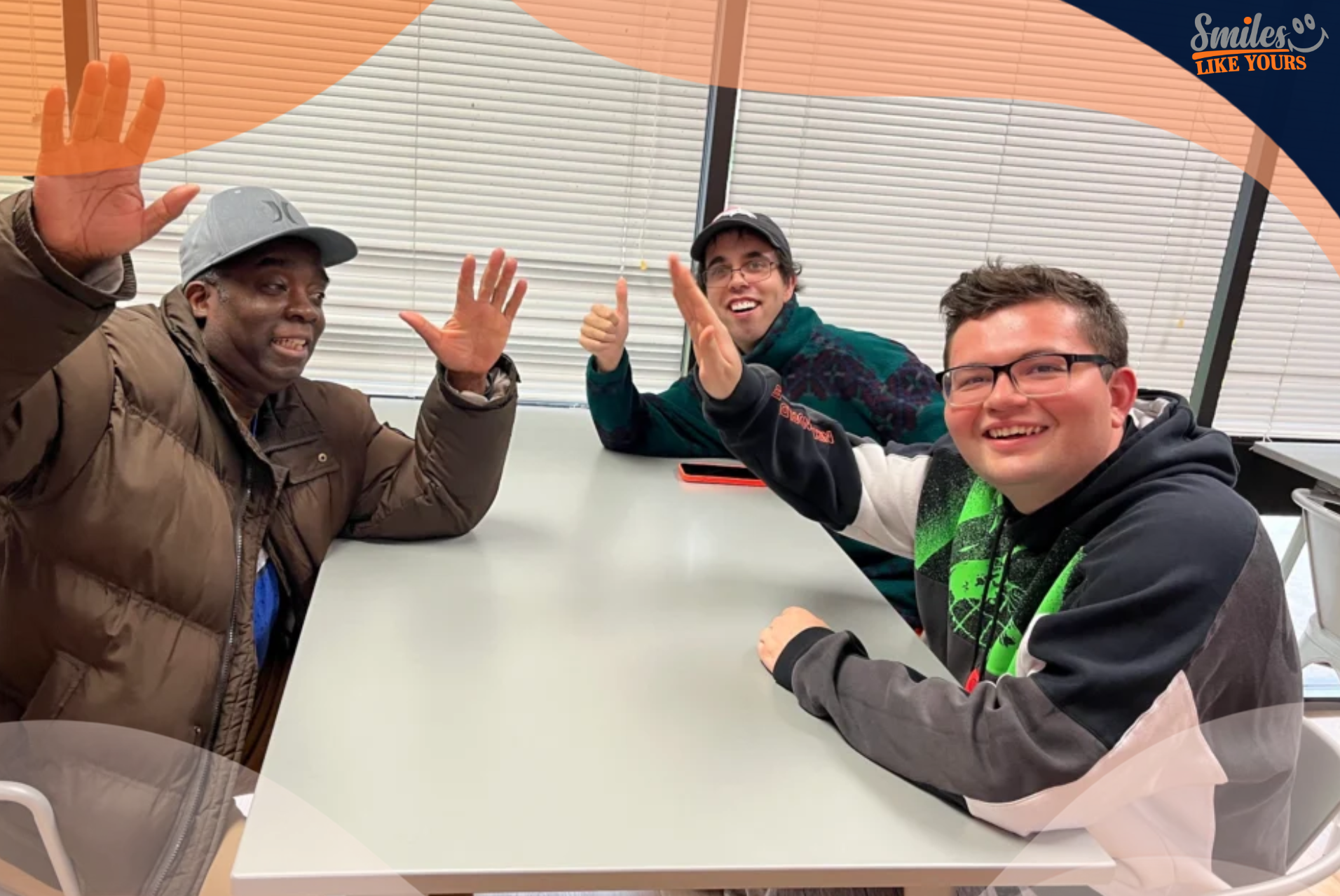 Three adults with developmental disabilities smiling and waving during a Smiles Like Yours group activity.