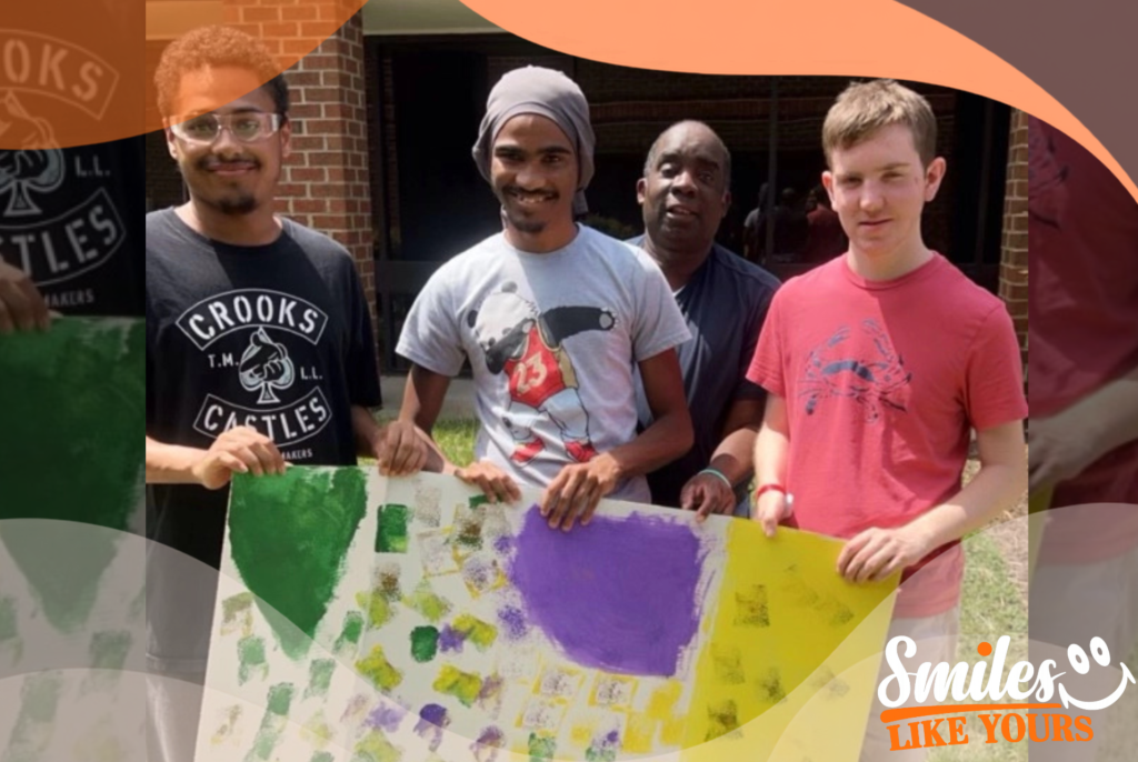 Adults with developmental disabilities displaying colorful artwork created during a group activity.