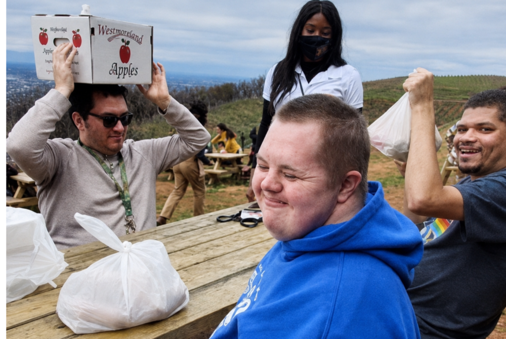 Adults with developmental disabilities enjoying an apple-picking community outing in Virginia.