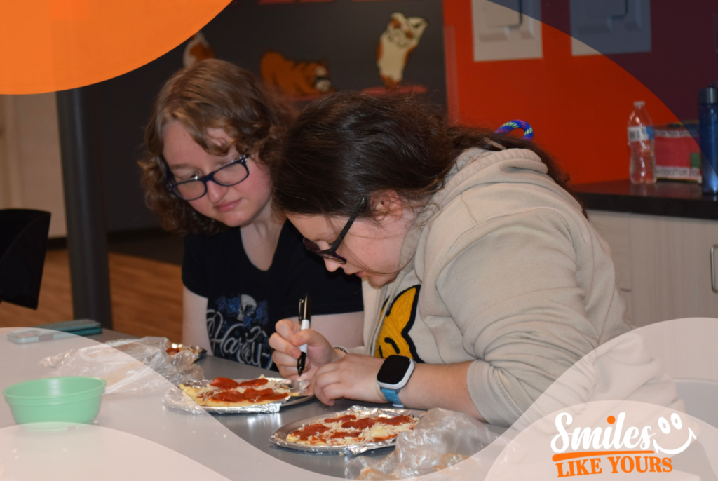 Adults preparing personal pizzas during a practical life skills activity at Smiles Like Yours.