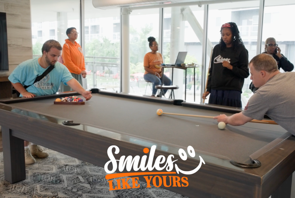 Adults participating in a group activity supported by visual schedules and structured routines at Smiles Like Yours. Description: