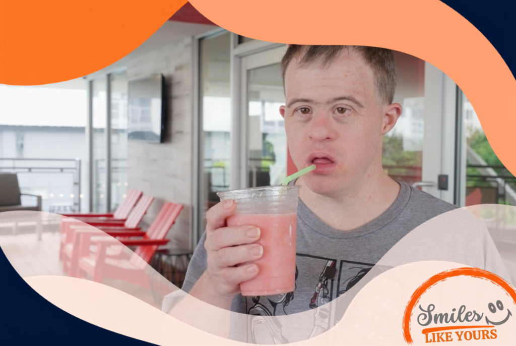 Adult participant holding a pink smoothie during a sensory-friendly activity.