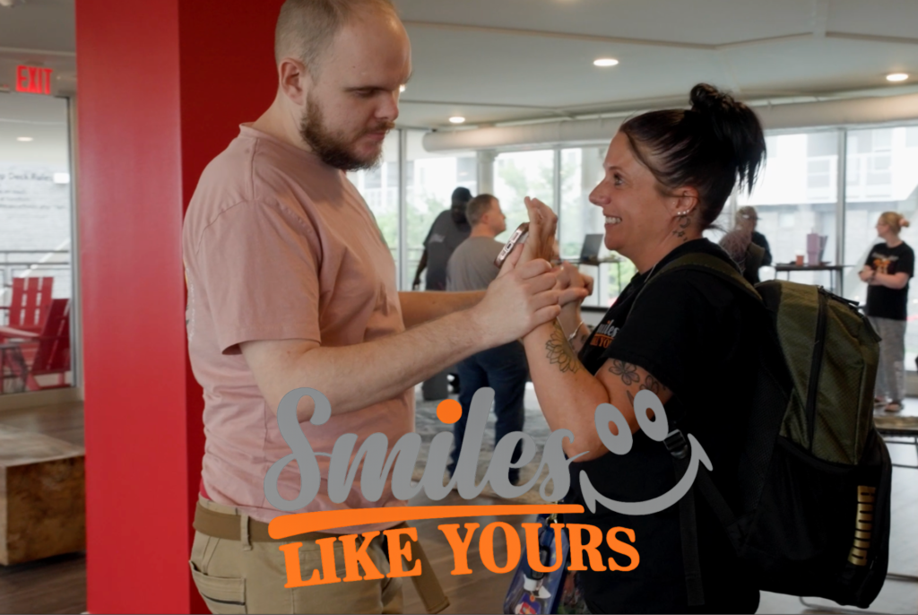 Adult participant engaging in a supportive one-on-one interaction at a Smiles Like Yours community event.