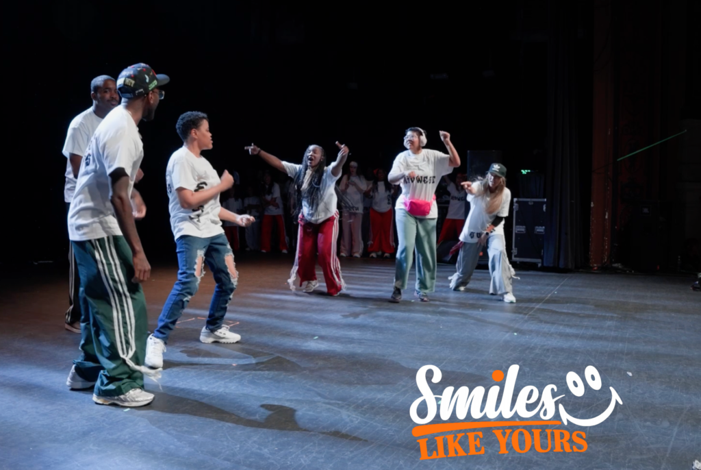 Adults dancing together on stage during an inclusive community performance.